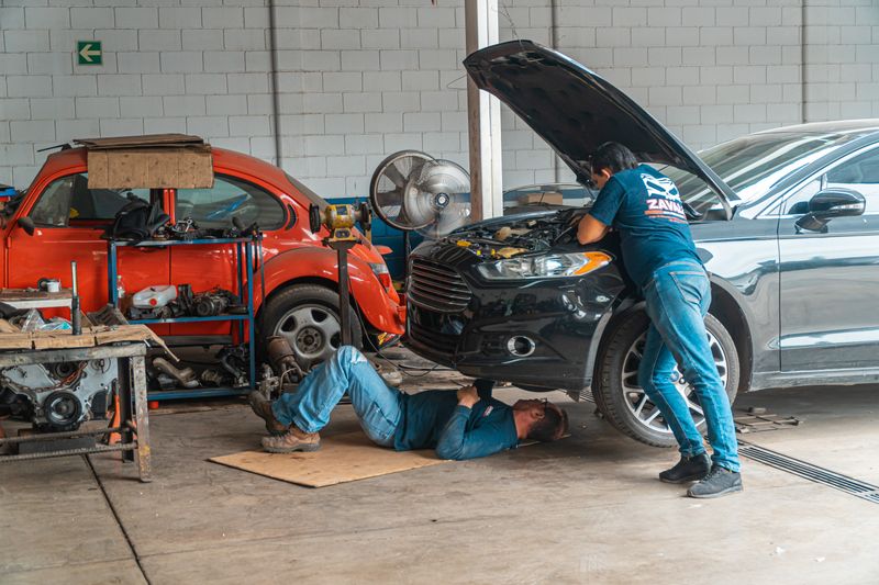 a man watching his car get fixed by a mechanic
